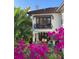 Mediterranean style house with a balcony, surrounded by lush tropical foliage and bright pink bougainvillea at 601 Bosphorous Ave, Tampa, FL 33606