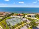 Aerial view of waterfront homes with tennis courts, a playground and ocean views at 6315 Marbella Blvd, Apollo Beach, FL 33572