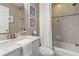Well-lit bathroom features a shower with tile surround, a sink with a white vanity and granite counter at 6315 Marbella Blvd, Apollo Beach, FL 33572