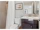 Bathroom features a vanity with dark cabinets, a framed mirror, and a shower with tiled walls at 6315 Marbella Blvd, Apollo Beach, FL 33572