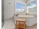 Bright bathroom features a large soaking tub with tiled surround and natural light from the double windows at 6315 Marbella Blvd, Apollo Beach, FL 33572