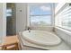 Bright bathroom features a large soaking tub with tiled surround and natural light from the double windows at 6315 Marbella Blvd, Apollo Beach, FL 33572