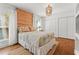 Relaxing bedroom with hardwood floors, a light colored quilt, decorative lighting, and many storage spaces at 6315 Marbella Blvd, Apollo Beach, FL 33572