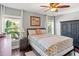 Cozy bedroom with hardwood floors, windows with palm tree views, and ceiling fan at 6315 Marbella Blvd, Apollo Beach, FL 33572