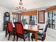 Dining room with a wooden table, upholstered chairs, woven blinds, and natural light at 6315 Marbella Blvd, Apollo Beach, FL 33572