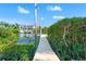 A private wooden dock stretches into the calm waters, surrounded by lush vegetation and neighboring homes at 6315 Marbella Blvd, Apollo Beach, FL 33572