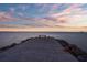Secluded dock view with a serene bench offering stunning oceanfront sunsets at 6315 Marbella Blvd, Apollo Beach, FL 33572