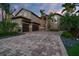 A luxurious home boasting a paver driveway, three-car garage, and lush tropical landscaping at 6315 Marbella Blvd, Apollo Beach, FL 33572