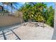 Stone fire pit with chairs on a gravel patio, surrounded by lush landscaping and a fence for an inviting outdoor space at 6315 Marbella Blvd, Apollo Beach, FL 33572