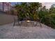 A cozy stone fire pit with seating, set against a backdrop of tropical greenery and a twilight sky, creating a relaxing ambiance at 6315 Marbella Blvd, Apollo Beach, FL 33572