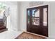 Bright foyer featuring a dark wood front door, tile floors, and staircase at 6315 Marbella Blvd, Apollo Beach, FL 33572