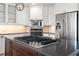Updated kitchen with stainless steel appliances, a cooktop island, and modern lighting fixtures at 6315 Marbella Blvd, Apollo Beach, FL 33572