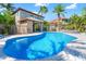 A backyard pool with blue, clear water, surrounded by tropical landscaping and a paved deck, offers a relaxing oasis at 6315 Marbella Blvd, Apollo Beach, FL 33572