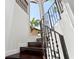 An elegant staircase with dark wood steps and an ornate black railing, bathed in natural light at 6315 Marbella Blvd, Apollo Beach, FL 33572