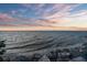 Stunning waterfront view with a picturesque sunset and rocky shoreline at 6315 Marbella Blvd, Apollo Beach, FL 33572
