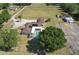 Home with a screened pool, horse stables, circle driveway, and mature landscaping in an aerial view at 6709 W Knights Griffin Rd, Plant City, FL 33565