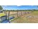 Wide view of the horse paddocks with water troughs and perimeter fencing on this equestrian estate at 6709 W Knights Griffin Rd, Plant City, FL 33565