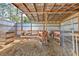 Interior view of horse stalls with wood framing and metal siding, with horses inside the stalls at 6709 W Knights Griffin Rd, Plant City, FL 33565