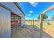 Horse stall with a brown horse looking out, featuring metal and wood construction under a blue sky at 6709 W Knights Griffin Rd, Plant City, FL 33565