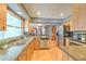 Beautiful kitchen with stainless appliances, stone countertops, and wood cabinets and flooring at 6709 W Knights Griffin Rd, Plant City, FL 33565