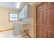 Laundry room with washer, dryer, utility sink, cabinets and doorway at 6709 W Knights Griffin Rd, Plant City, FL 33565