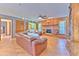 Comfortable living room with leather seating, brick fireplace, and wood paneling at 6709 W Knights Griffin Rd, Plant City, FL 33565