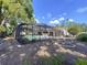 Spacious screened-in pool and backyard of this home with lush greenery and a well-maintained lawn at 7307 Summerbridge Dr, Tampa, FL 33634