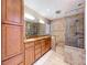 Bathroom featuring double sinks, granite countertops, a glass shower and custom cabinets at 7307 Summerbridge Dr, Tampa, FL 33634
