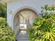 A charming gated entrance leads into the home's courtyard amidst lush landscaping at 7307 Summerbridge Dr, Tampa, FL 33634