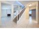 Open foyer with staircase and tile flooring leads to the living spaces of the home at 7307 Summerbridge Dr, Tampa, FL 33634
