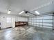 Spacious garage with overhead lighting, storage cabinets, and workbench at 7307 Summerbridge Dr, Tampa, FL 33634