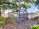 Backyard greenhouse is ready for your plants surrounded by mulch, lush plants and a privacy fence at 7307 Summerbridge Dr, Tampa, FL 33634