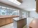 Well-lit kitchen features a large island and a wall of windows offering views of the backyard at 7307 Summerbridge Dr, Tampa, FL 33634
