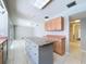 Open kitchen with an island features tile flooring and cabinets with lots of storage space at 7307 Summerbridge Dr, Tampa, FL 33634