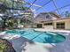 Relaxing screened-in pool with clear blue water and spacious patio area with home exterior in the background at 7307 Summerbridge Dr, Tampa, FL 33634