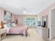 Bright and airy bedroom with pink walls, ceiling fan, and plantation shutters for ample light at 9110 34 N Way, Pinellas Park, FL 33782