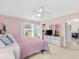 Charming bedroom features a ceiling fan, plantation shutters, and an ensuite bathroom at 9110 34 N Way, Pinellas Park, FL 33782