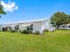 Exterior view of a well-maintained home with awnings, landscaping, and a green lawn at 9110 34 N Way, Pinellas Park, FL 33782