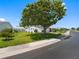 Charming home exterior with lush green lawn, mature trees, and a paved street at 9110 34 N Way, Pinellas Park, FL 33782