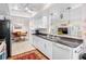 Bright kitchen with white cabinets, granite countertops, and a breakfast bar overlooking the dining area at 9110 34 N Way, Pinellas Park, FL 33782