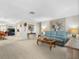 Open living room with a light blue sofa, decor lighting, and a beautiful floral design painting at 9110 34 N Way, Pinellas Park, FL 33782