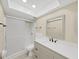 Bathroom featuring a single sink vanity, updated fixtures, and a walk-in shower with glass doors at 100 Glennes Ln # 108, Dunedin, FL 34698
