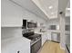 Well-lit kitchen featuring stainless steel appliances, countertops, and white cabinets at 100 Glennes Ln # 108, Dunedin, FL 34698