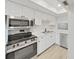 Modern kitchen showcasing stainless steel appliances, sleek countertops, and ample white cabinetry at 100 Glennes Ln # 108, Dunedin, FL 34698