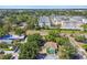This aerial shot shows a cozy home surrounded by green trees and modern apartment buildings at 1046 Yale N St, St Petersburg, FL 33713