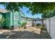 Green home exterior with a backyard gazebo, white fence, and partial deck, offering a serene outdoor space at 1046 Yale N St, St Petersburg, FL 33713