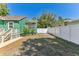 Backyard features a white fence, grassy area and the side of a charming green home with a wooden deck at 1046 Yale N St, St Petersburg, FL 33713
