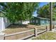 Green house featuring a spacious backyard with mature trees and a classic wooden fence at 1046 Yale N St, St Petersburg, FL 33713