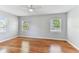 Bright bedroom with wood floors, white ceiling fan, and ample natural light from multiple windows at 1046 Yale N St, St Petersburg, FL 33713