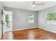 A sunlit bedroom featuring hardwood floors, neutral paint, and an ensuite bathroom at 1046 Yale N St, St Petersburg, FL 33713